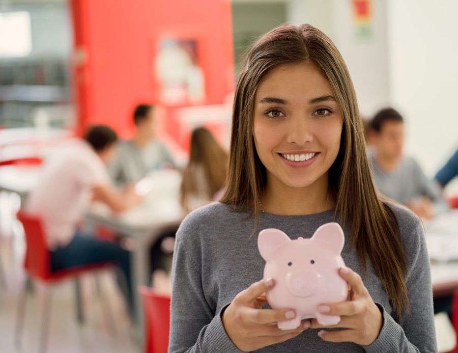 Teen girl with pink piggy bank